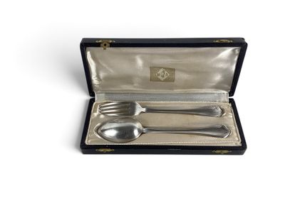 un ancien service d'argenterie dans un coffret noir posé sur une surface blanche