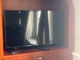 un téléviseur à écran plat posé sur un centre de divertissement en bois