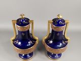 pair of blue and gold vases with handles on each side