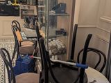 tables and chairs in a small room with a glass case in the background