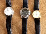 three different types of watches sitting on top of a brown surface
