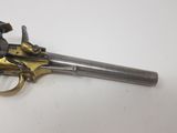 a silver and gold revolver on a white surface