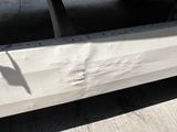 a close up of a white truck with a shadow on the ground