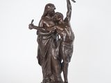 une statue en bronze représentant un homme et une femme tenant un oiseau