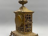 an antique brass clock sitting on top of a wooden stand