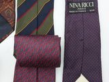three different colored ties are lined up on a white surface