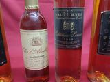 several bottles of wine are lined up on a pink table