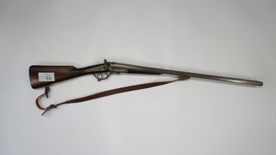 an old rifle with a wooden handle and a leather strap