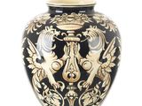 un vase noir et doré orné d'un motif représentant un lion