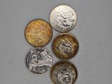 four different types of coins sitting on top of a white surface