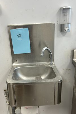 un évier en acier inoxydable dans le coin d'une salle de bains