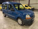 La petite camionnette bleue est garée dans un garage avec d'autres voitures.