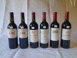 six bottles of wine are lined up on a table