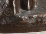 a bronze statue of a man sitting on a bench
