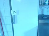 a white refrigerator in a small kitchen with a trash can