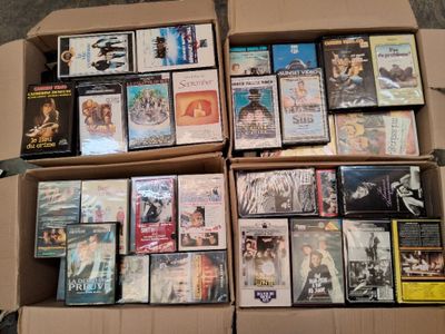un grand nombre de dvd dans une boîte posée sur le sol