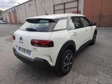 the rear end of a white citrole parked in a parking lot