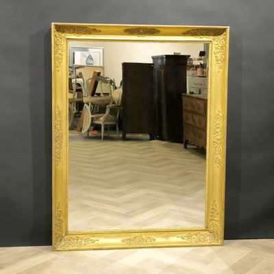 a large gold framed mirror on the floor in a room