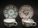 deux tasses et soucoupes ornées de motifs floraux sur fond noir