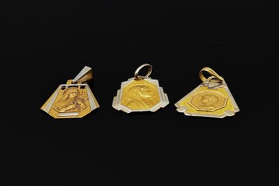 trois médailles d'or sur lesquelles figurent l'image d'un homme et d'une femme