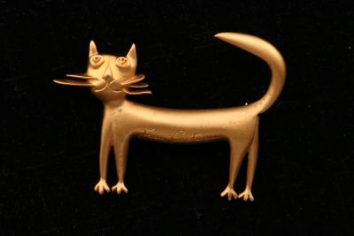 une broche en forme de chat doré sur fond noir