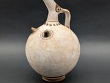a white vase with a bird on it on a black background