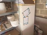 a refrigerator in the corner of a room with a lot of stuff on the shelves