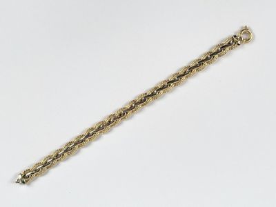 gros plan d'un bracelet en or sur une surface blanche