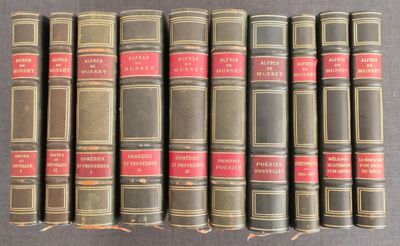six vieux livres sont alignés sur une surface grise