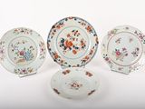 three plates and a bowl are sitting on a white surface