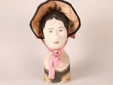 a ceramic head of a woman wearing a pink hat
