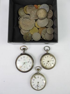 three silver pocket watches and a box of coins on a white surface