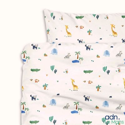 an image of a bed with a white sheet with a pattern of animals on it