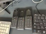 several cell phones are lined up on a desk next to a keyboard
