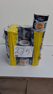 Plusieurs canettes de soda sont empilées sur une table, avec une étiquette de prix