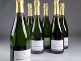 six bouteilles de champagne sont alignées sur une table