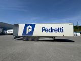 the trailer is parked in front of a building with a blue and white logo on it