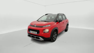 Une Citroën rouge est garée dans une pièce blanche
