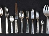a lot of silver spoons and forks on a table