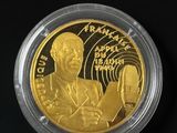 a close up of a gold coin with a man holding a microphone