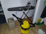 un aspirateur jaune et une table à repasser noire dans une pièce