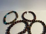 trois bracelets composés de perles « œil-de-tigre » sur un fond blanc