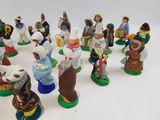many figurines of different people on a white surface
