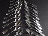 a lot of forks and spoons on a black table