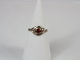 a close up of a ring with a red stone in it