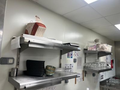 une cuisine avec de nombreuses étagères et de la vaisselle posée sur le plan de travail