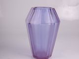 vase en verre violet posé sur une surface blanche, avec des nuages en arrière-plan