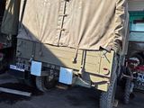 two army vehicles parked in a garage next to each other