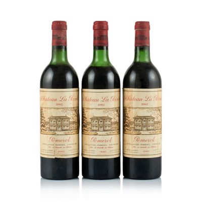 three bottles of red wine sitting next to each other on a white surface