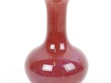 a red vase that is sitting on a white surface